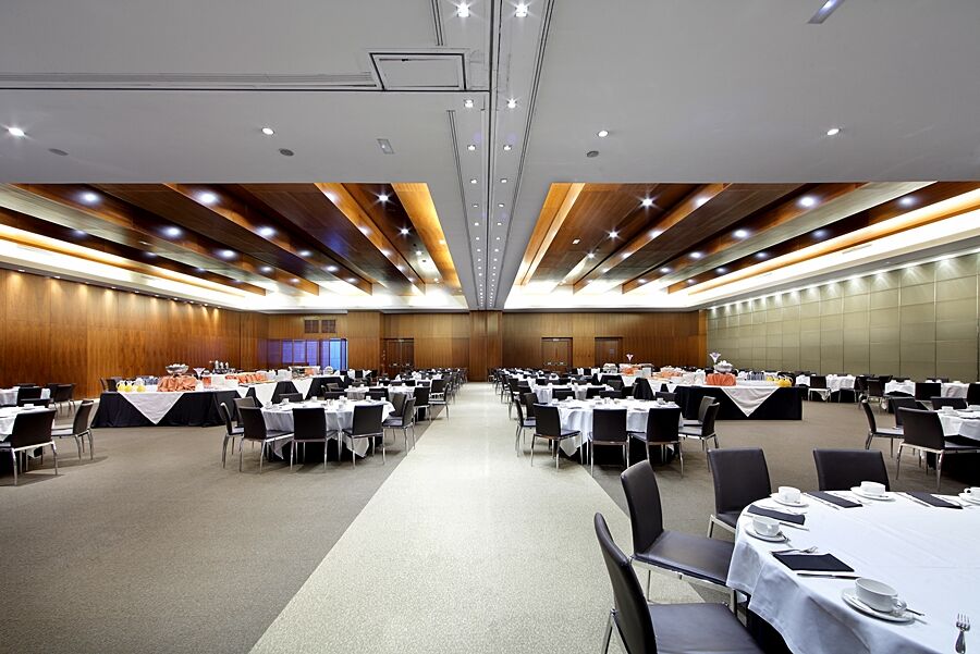 유로스타 마드리드 타워 외부 사진 The photo depicts a spacious banquet hall or conference room. It features a series of tables arranged in a grid pattern, covered with white tablecloths and adorned with black tablecloths at the edges. Each table is set with plates, cutlery, and glass